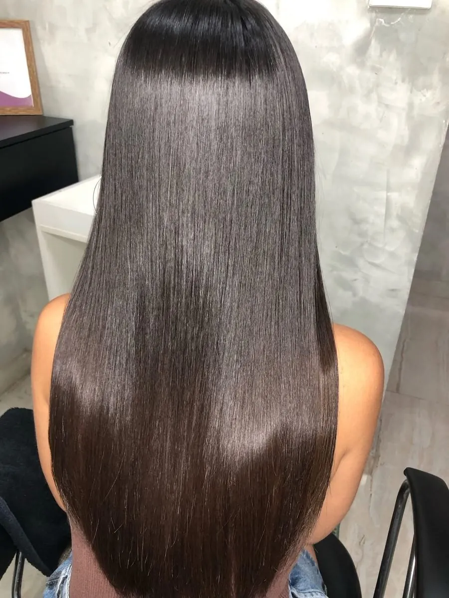 Costas de cabelo longo, liso, escuro e com brilho espelhado