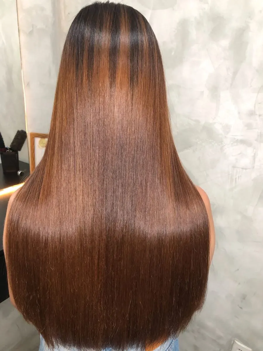 Costas de cabelo longo e liso com reflexos acobreados e muito brilho