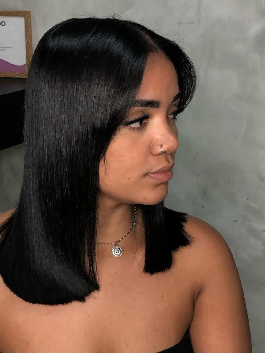 Long bob preto liso com franja lateral, visto de perfil
