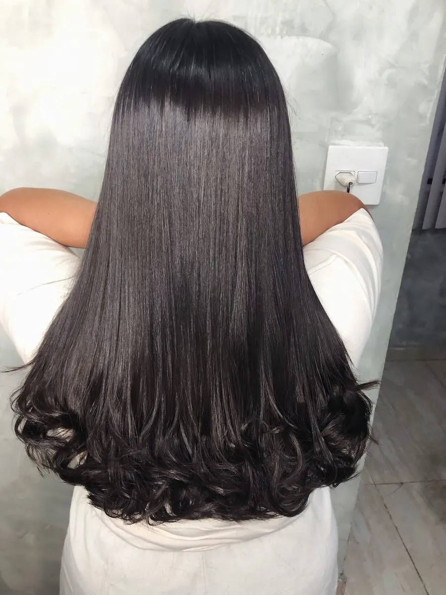 Costas de cabelo longo, liso no comprimento e com as pontas modeladas em cachos