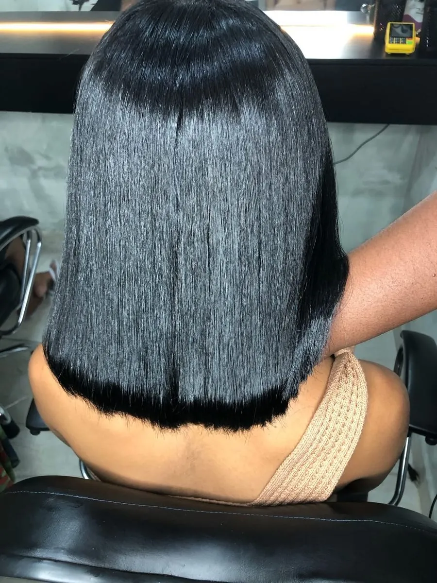 Costas de um chanel preto, liso, com pontas retas e brilho intenso
