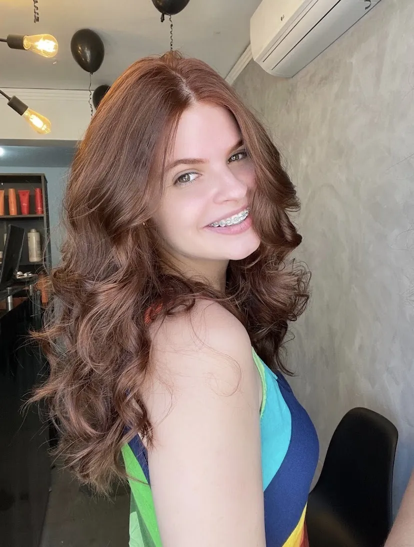Cliente ESPCI com cabelo castanho, cachos volumosos