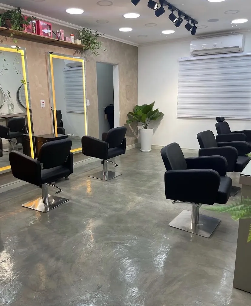 Salão com poltronas de couro preto e espelhos emoldurados em dourado
