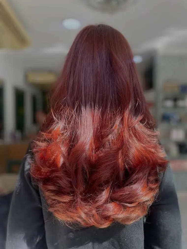 Coloração ruiva vibrante com pontas em cachos, vista de costas